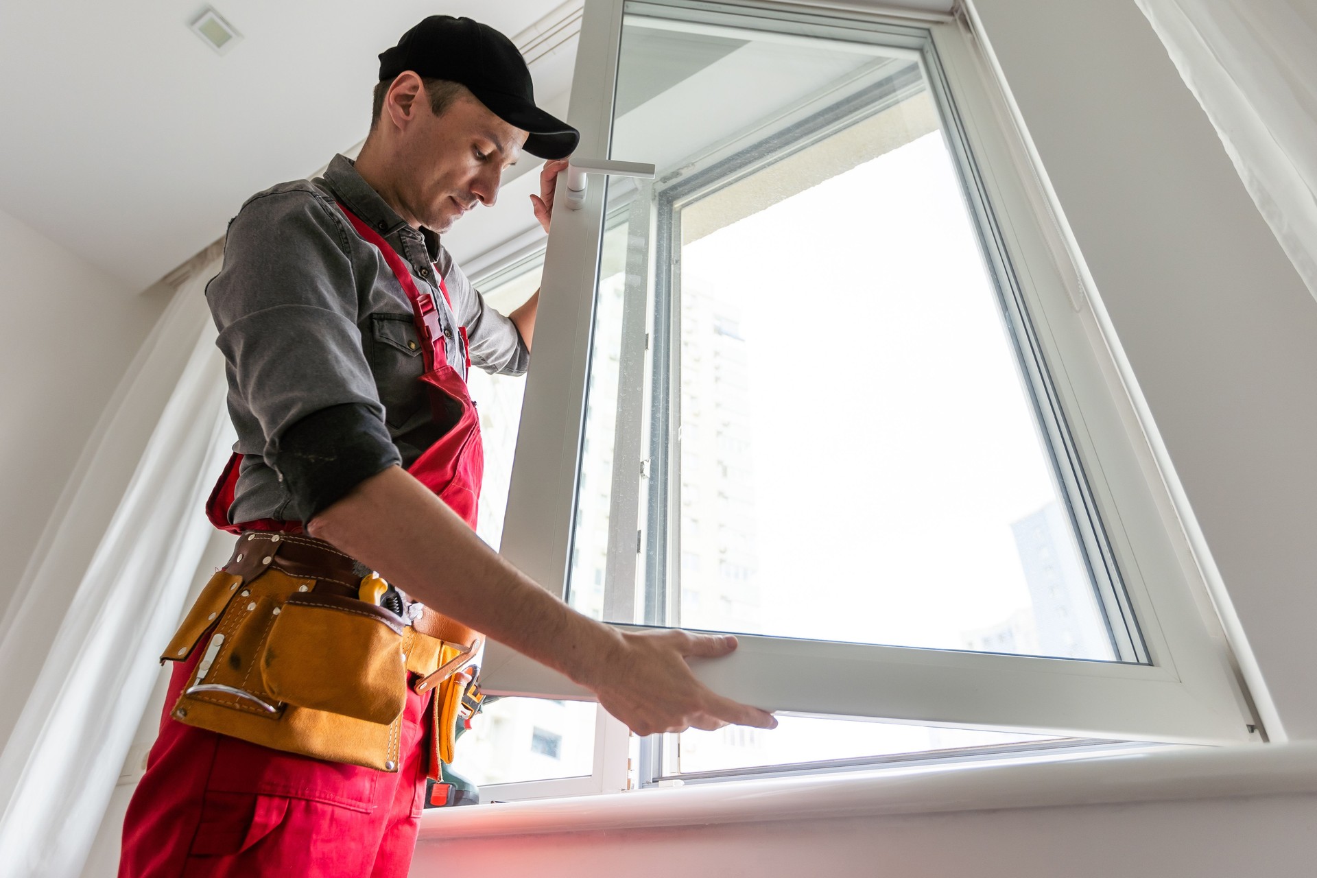 Cheerful young man mounting a kitchen window